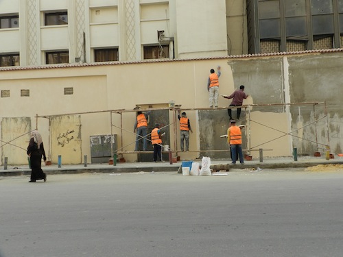 Des agents effaçant les graffitis en préparation des célébrations officielles du premier anniversaire de la révolution du 25 janvier.